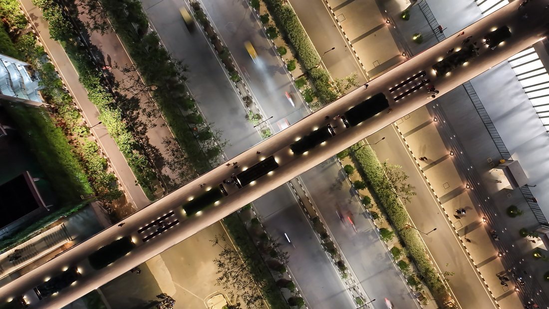 A top-down aerial of a lit highway interchange at night