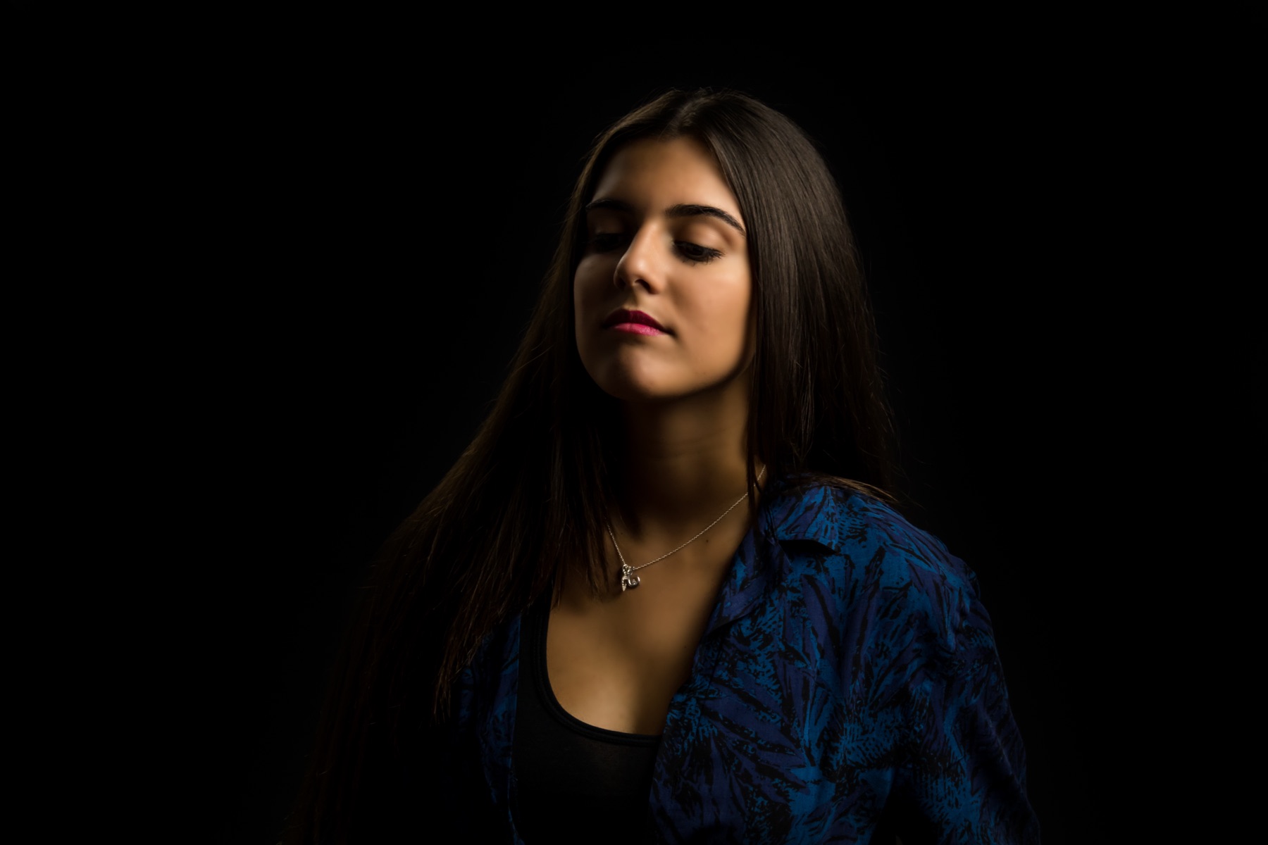A low-key studio portrait shot against a black backdrop in the Spotlight Studio